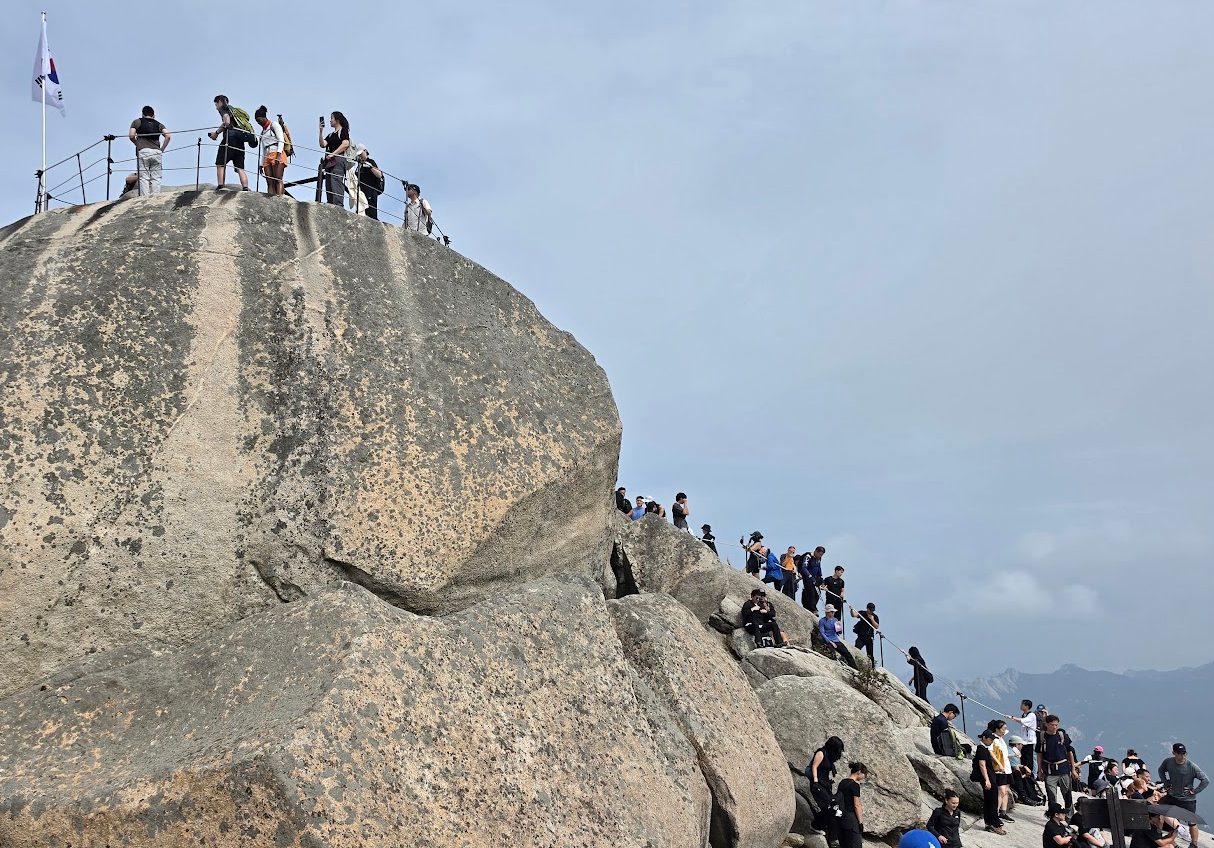 Pendaki di puncak berbatu Baegundae Bukhansan